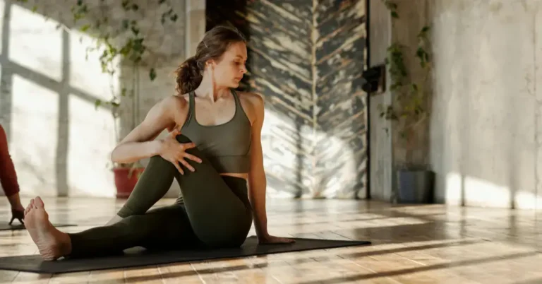 Woman in brown leggins and sports bra doing yoga inside